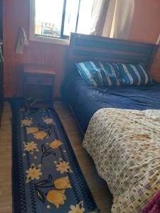 a bedroom with a bed and a table with a blanket at Cabaña lancuyen in Futrono