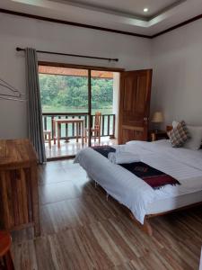 a bedroom with a large bed and a large window at Nam ou view villa in Nongkhiaw