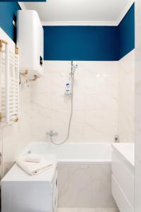 a bathroom with a white tub and a blue ceiling at Újbuda Rest Apartment With Air Condition and Balcony in Budapest