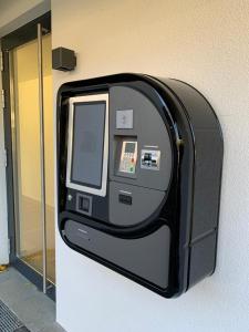 aan de zijkant van een gebouw is een machine bevestigd bij Motel by Maier Feldkirch - kontaktloser Check-in in Feldkirch