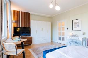 a bedroom with a bed and a table and a tv at Újbuda Rest Apartment With Air Condition and Balcony in Budapest