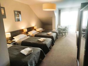 pokój hotelowy z 4 łóżkami i ręcznikami w obiekcie Pensjonat u Marianny w mieście Augustów +27 zdjęć