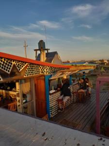 people sitting on the deck of a boat at Lobo Hostel Bar in Cabo Polonio