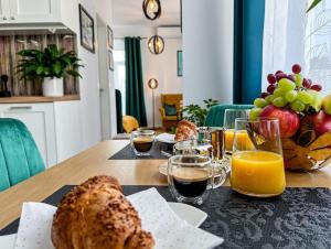 - une table avec du pain, des fruits et des verres de jus d'orange dans l'établissement Art deco studio in Old town, à Bratislava