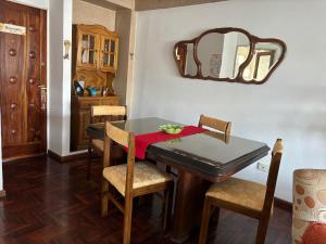 una sala da pranzo con tavolo, sedie e specchio di Tintes de Otoño a San Miguel de Tucumán