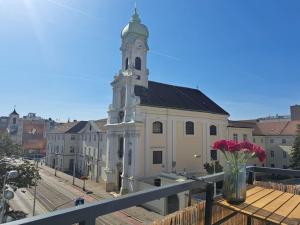 a building with a tower with a vase of flowers on a balcony at Art deco studio in Old town in Bratislava
