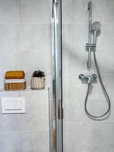 a shower with a glass door in a bathroom at Art deco studio in Old town in Bratislava