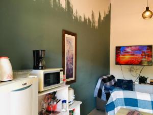 a living room with a tv and a microwave at hospedagem Manaká proximo ao Centro vista incrível in Cunha