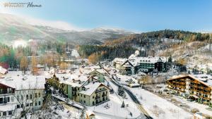 カルパチにあるWonder Home - Apartament Zaciszny z kominkiem i balkonem z widokiem na Śnieżkęの雪の中の町の空の景色