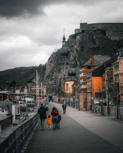 a group of people walking on a bridge near a harbor at L'Essentiel in Dinant