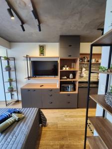 a living room with a large television and a couch at Lofts | Consolação | 3 min Metrô in Sao Paulo