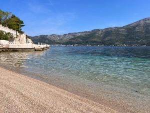 a large body of water with mountains in the background at Villa Jade Apartments FRONT ROW SEA VIEW - WALK TO KORCULA OLD TOWN in Korčula