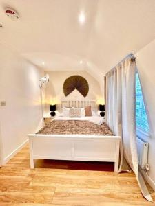 um quarto com uma cama branca e uma janela em H4: Fantastic Apartment - 100m from Piccadilly Circus em Londres