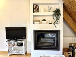 a living room with a fireplace and a tv at Dúplex en Sallent de Gállego in Sallent de Gállego