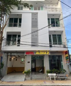 un edificio blanco con un cartel delante en Hotel Aloha 2, en Ninh Hải