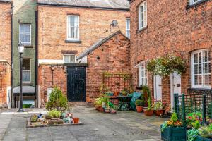 a brick building with a courtyard with potted plants at Gamul Place - Quiet City Centre in Chester