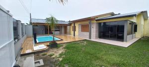 a house with a backyard with a swimming pool at Casa Com Quatro Dormitórios Pertinho Do Mar Em Capão Da Canoa in Capão da Canoa
