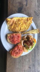 a plate of food with breakfast foods on a table at Lobo Hostel Bar in Cabo Polonio