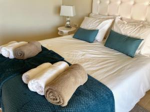 a large white bed with towels on it at Superior apartment for golf, sea and nature lovers in Casares