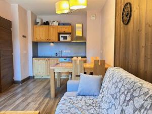 een woonkamer met een bank en een tafel en een keuken bij Appartement Risoul, 2 pièces, 4 personnes - FR-1-330-563 in Risoul