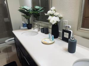 uma casa de banho com um lavatório com flores em NRG Stadium - 2 Bedroom 2 Bath Apartment with Amenities em Houston