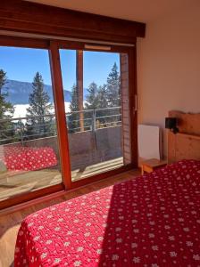 a bedroom with a bed and a large window at Arolles D21 - Chamrousse 1700 - Les Villages du Bachat in Chamrousse