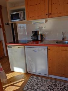 a kitchen with white appliances and a red counter top at Arolles D21 - Chamrousse 1700 - Les Villages du Bachat in Chamrousse