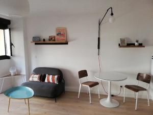een woonkamer met een bank en een tafel en stoelen bij Appartement '' L'Ossau '' hyper centre Place Clémenceau in Pau