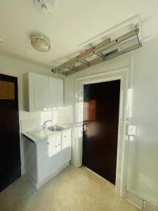 an empty kitchen with a sink and a door at The Traders Inn in London