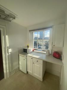 a white kitchen with a counter and a window at The Traders Inn in London