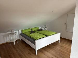 a bed with green pillows on it in a room at 5-Zimmer-Maisonette Wohnung in Oberbalzheim