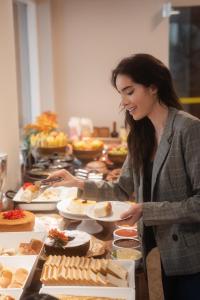 una mujer sosteniendo un plato de comida en un buffet en Fortaleza Mar Hotel, en Fortaleza