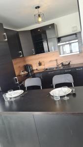 uma sala de jantar com mesa e cadeiras e uma cozinha em Mon petit chez-toi Appart proche Parc des Expositions Aéroport CDG em Aulnay-sous-Bois