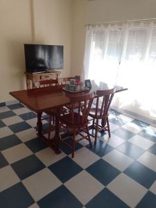 een eettafel met stoelen en een televisie bij Luminoso céntrico in Neuquén