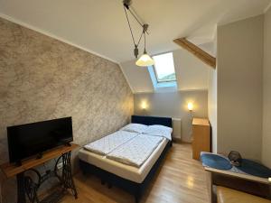 1 dormitorio con 1 cama y TV de pantalla plana en Dom Gościnny Gerus en Pławna