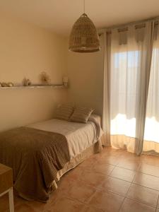 sypialnia z łóżkiem i dużym oknem w obiekcie Casa Bambolia w mieście Valdelinares