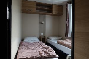 two beds are in a small room withermottermottermott at GHVacances PiPiou Lac de Parentis en Born in Parentis-en-Born