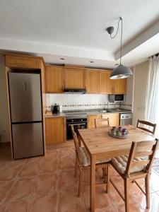 a kitchen with a wooden table and a refrigerator at Casa Bambolia in Valdelinares