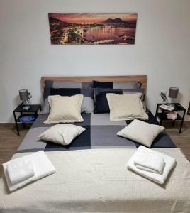 uma cama grande com quatro almofadas em cima em Casa comoda e centrale in quartiere storico di Napoli em Nápoles