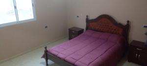 a bedroom with a purple bed with two night stands at Casa en Chilecito equipada cerca ruta 40 in Chilecito