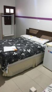 um quarto com uma cama com um cobertor preto e branco em HOTEL REQUINTE em Santa Luz