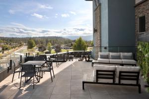 - un balcon avec des tables et des chaises dans un bâtiment dans l'établissement Fairfield Inn & Suites by Marriott West Kelowna, à West Kelowna