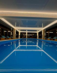 uma grande piscina com água azul em Gistola Hotel Mestia em Mestia