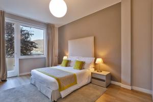 Un dormitorio con una cama grande y una ventana en Como Lake Suites, en Como