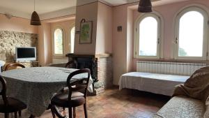 sala de estar con mesa, cama y ventanas en Villa Felici, en Giuliano di Roma