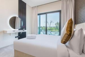 une chambre avec un grand lit blanc et une grande fenêtre dans l'établissement STAY BY LATINEM Luxury 1BR Holiday Home W102 near Burj Khalifa, à Dubaï 16 autres photos