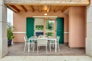 una mesa y sillas en un patio con puertas verdes en Tenuta di Palú, en Bardolino