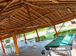 a pool table under a wooden pavilion with a pool table at Hotel flamingo real T in Mariquita