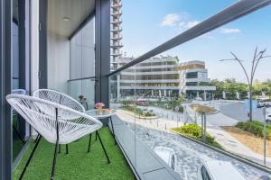 d'un balcon avec deux chaises et une vue sur la rue. dans l'établissement STAY BY LATINEM Luxury 1BR Holiday Home W102 near Burj Khalifa, à Dubaï
