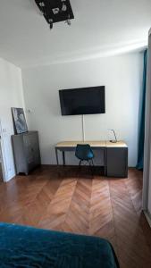 a room with a desk with a tv and a chair at Appartement 120 m² Standing Hyper Centre Climatisé in Perpignan